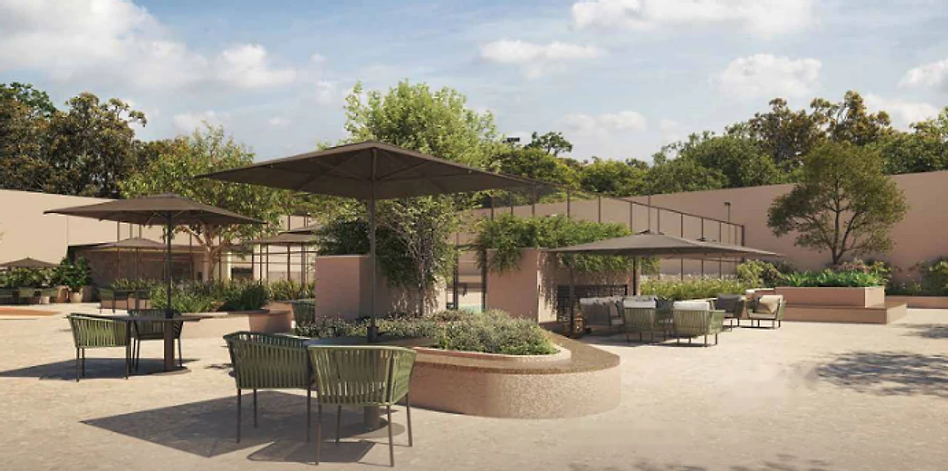Praça arborizada com ombrelones, bancos revestidos de granito e mesas ao ar livre